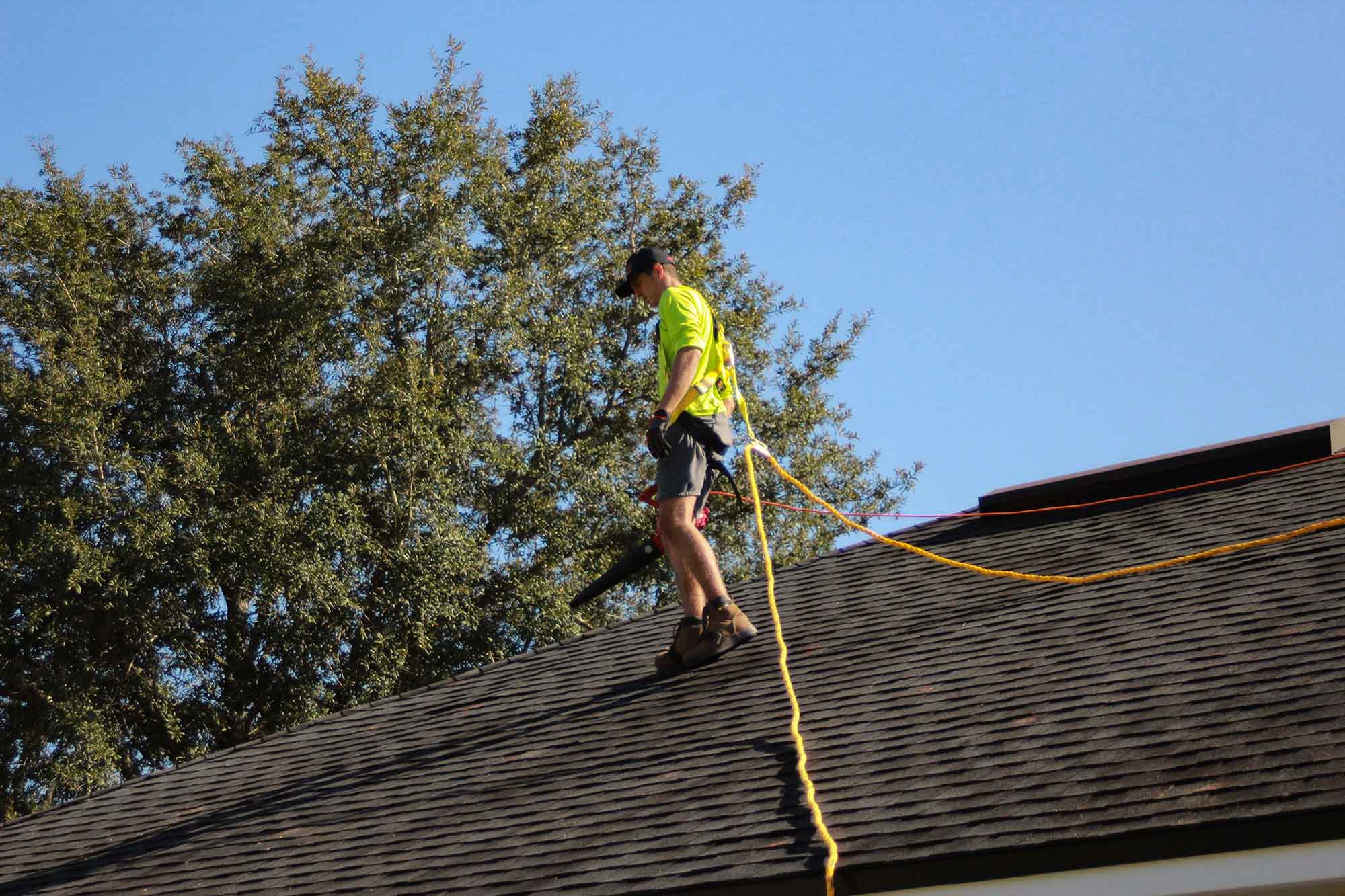 Technician inspecting a residential chimney and roof area