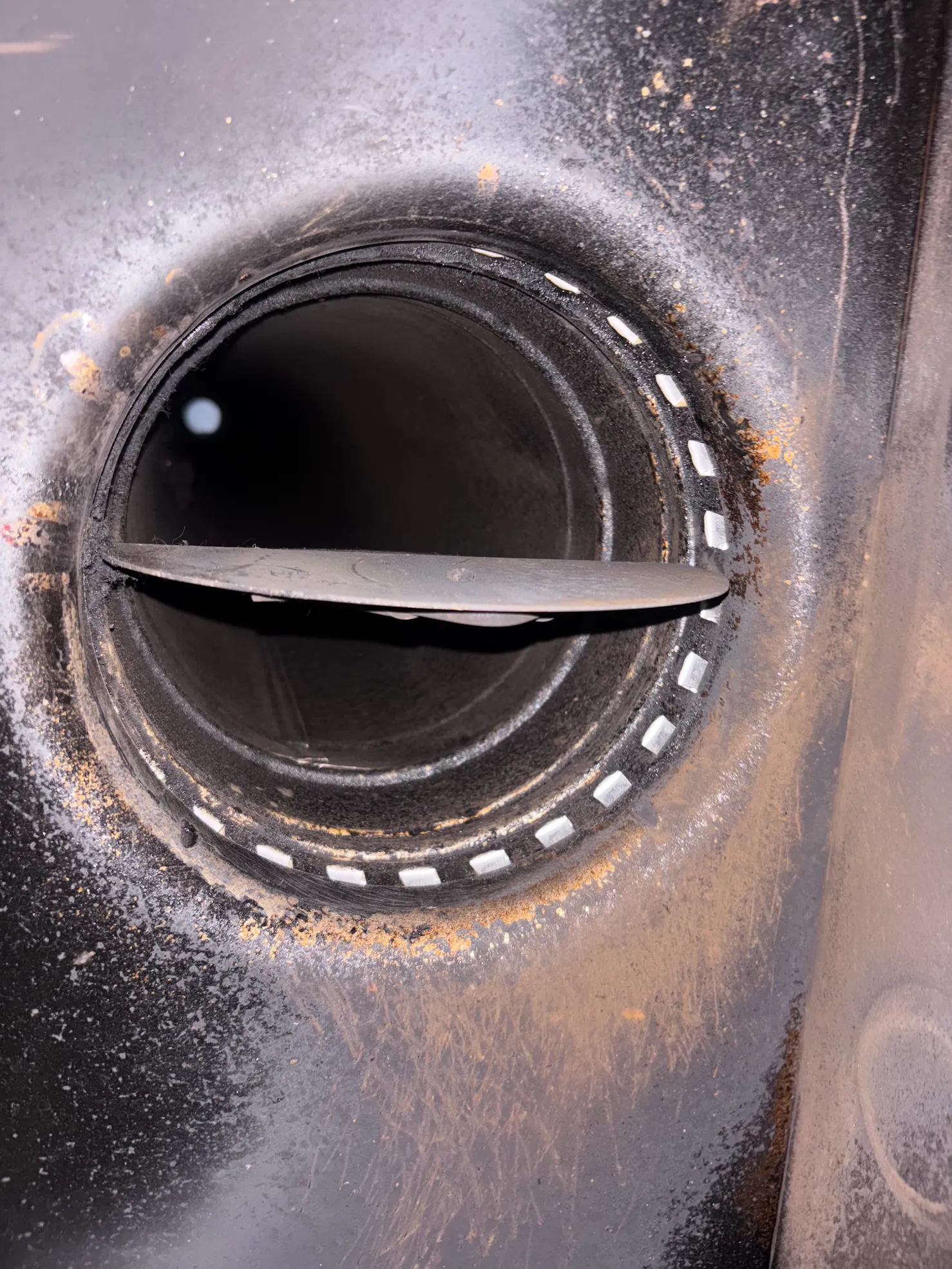Close-up of soot buildup inside a stove venting component