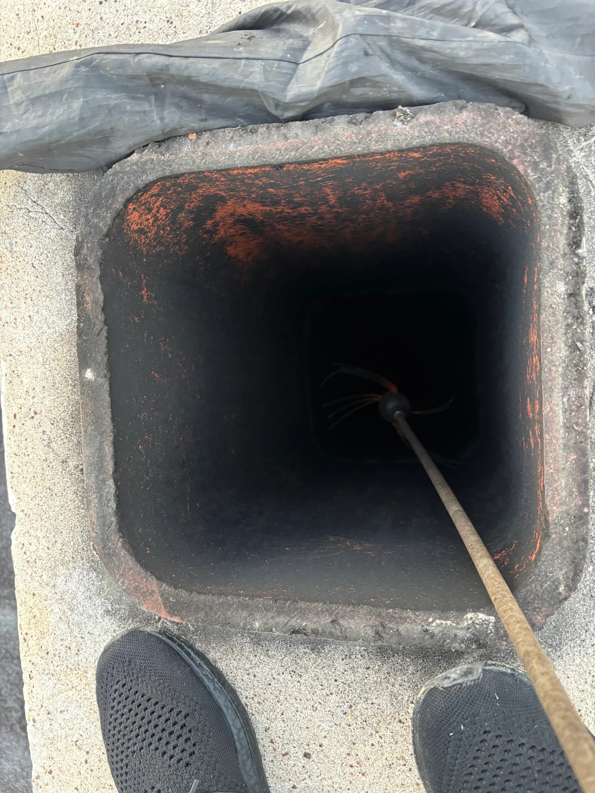 Chimney brush cleaning soot from a residential chimney flue